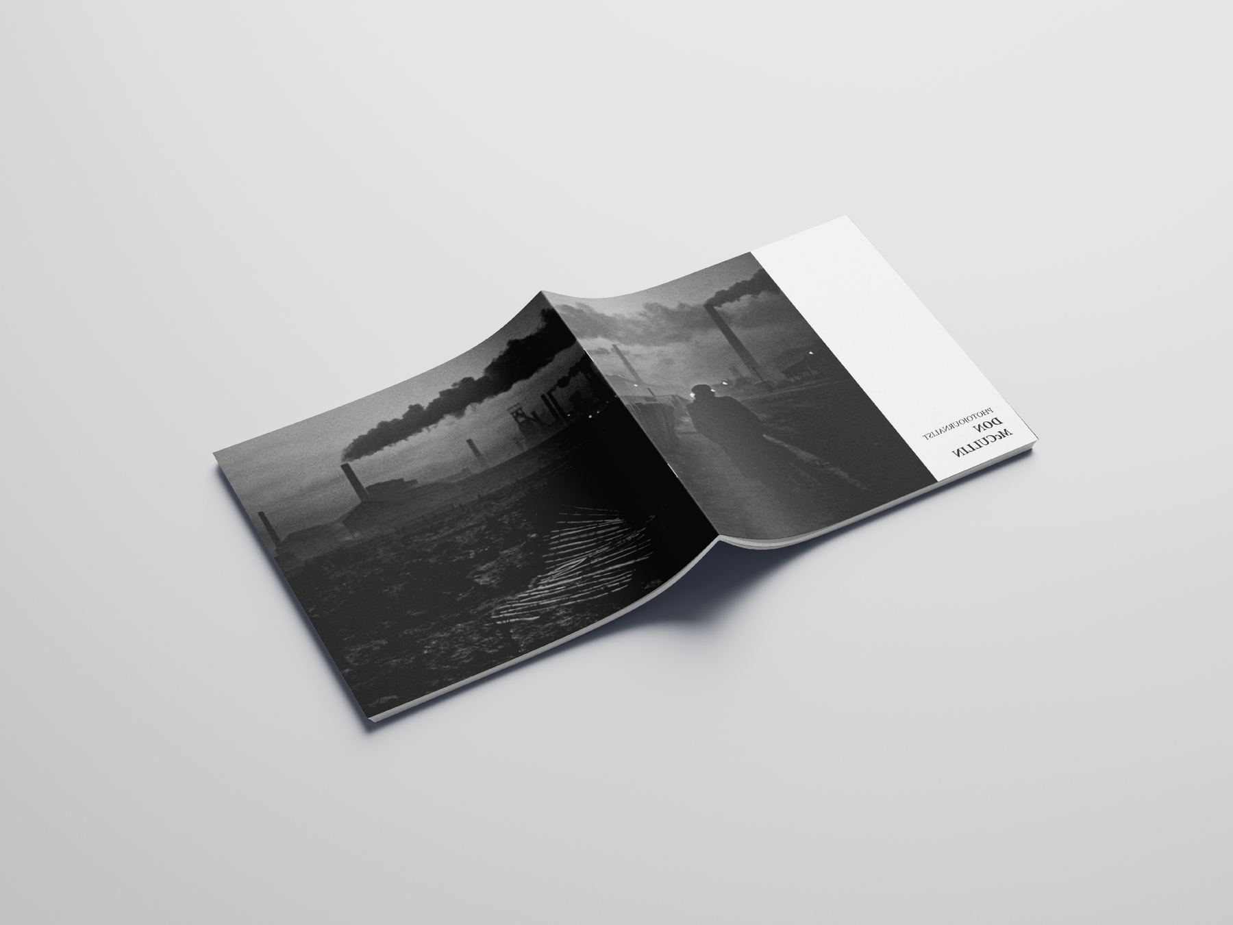 Photobook open to a full-bleed landscape photograph across the gutter